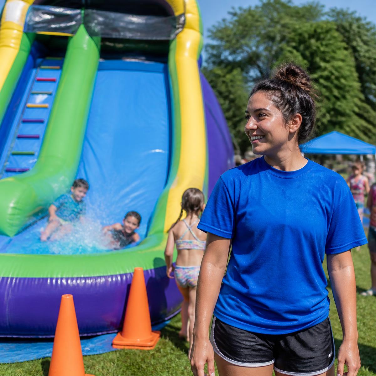 Event attendant watching kids on a water slide